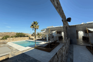 Außenansicht mit Pool und Liegen von Casa Mykonos tagsüber
