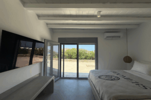 Bett mit Fernseher und Roomers Decke, Tür zum Außenbereich