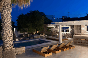 Außenansicht mit Pool und Liegen von Casa Mykonos in der Nacht