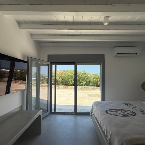 Bett mit Fernseher und Roomers Decke, Tür zum Außenbereich